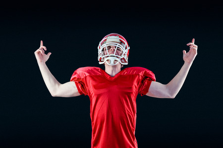 A triumph of an american football player with black backgroundの写真素材