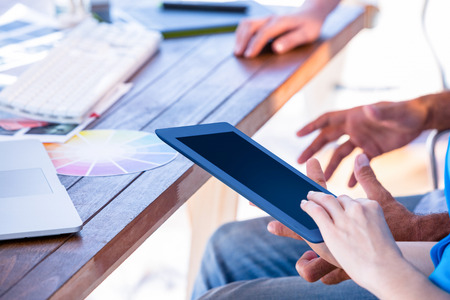 Close up of creative business people using tablet on white backgroundの写真素材