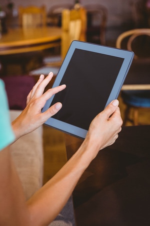 A woman using tablet computer at the cafeの写真素材