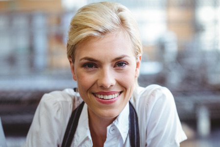 Selfassured female cook smiling in front of her bakeryの写真素材
