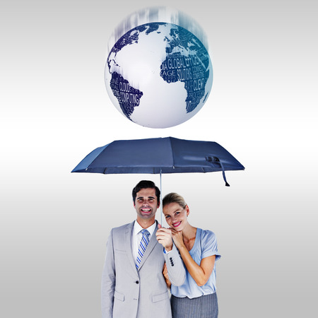 Business people holding a black umbrella against grey backgroundの写真素材