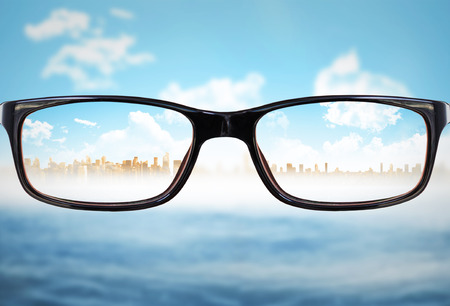 Glasses against cityscape on horizon over oceanの写真素材
