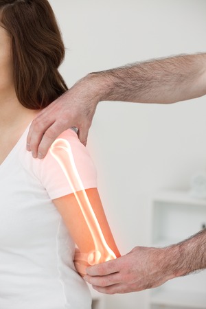 Digital composite of Highlighted bones of woman at physiotherapistの写真素材