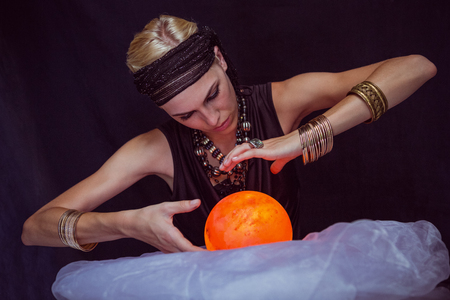 Fortune teller forecasting the future on black backgroundの写真素材