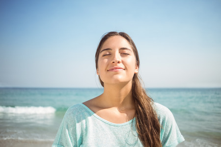 happy woman smiling at the camera at the beachの写真素材