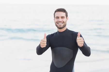 Man in wetsuit on a sunny day at the beachの写真素材