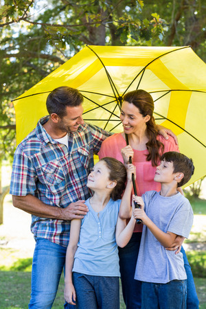 Happy family in the park together on a sunny dayの写真素材