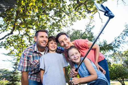 Happy family in the park taking selfie on a sunny day