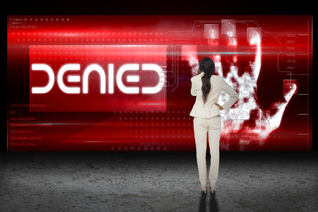 Thinking businesswoman against hand print authentication deniedの写真素材