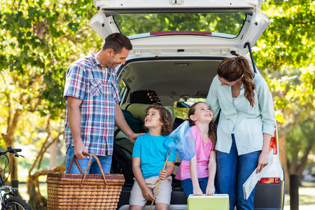 Happy family getting ready for road trip on a sunny dayの写真素材