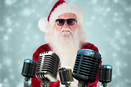 Santa Claus wears black sunglasses  against white snowflake design on blueの写真素材