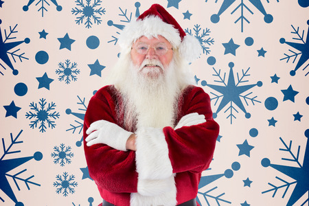 Santa smiles with folded arms against snowflake patternの写真素材