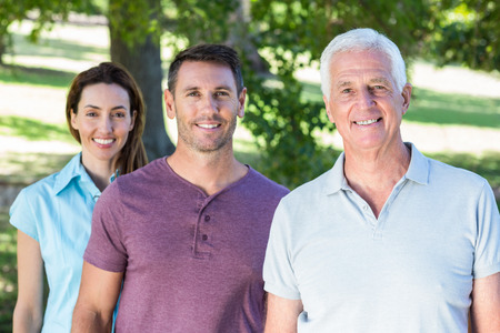 Extended family smiling in the park on a sunny dayの写真素材