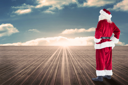 Santa looks away from the camera against floorboards in the skyの写真素材