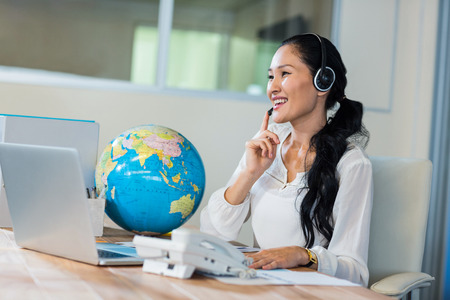 Pretty travel agent speaking to customer in the officeの写真素材