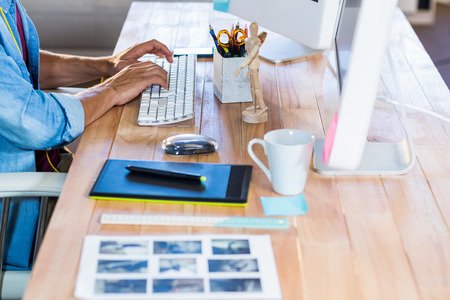 Businessman typing on keyboard at desk in the officeの写真素材