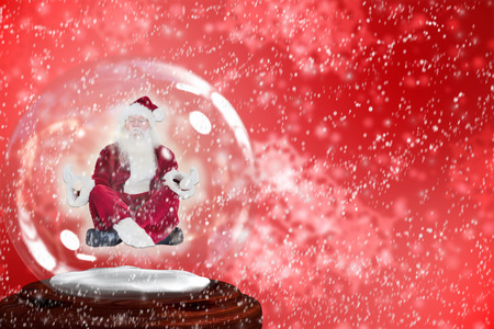 Santa doing yoga in snow globe against digitally generated delicate snowflake designの写真素材