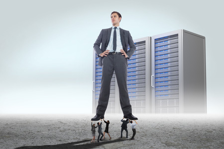 Business people supporting boss against server towers in desert settingの写真素材