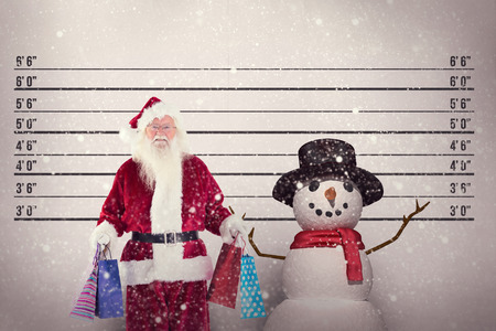 Santa carries some christmas bags against mug shot backgroundの写真素材