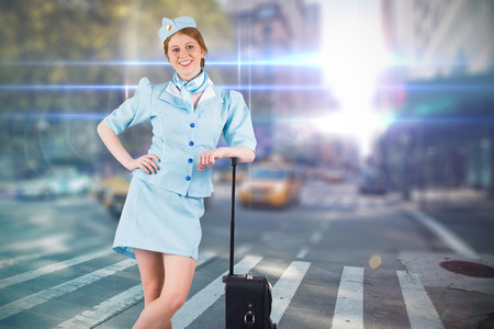 Pretty air hostess smiling at camera against blurred new york streetの写真素材