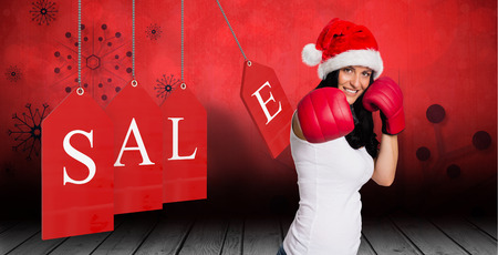 Woman wearing red boxing gloves against snowflake wallpaper over floor boardsの写真素材