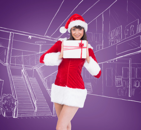 Sexy santa girl holding gift against purple vignetteの写真素材
