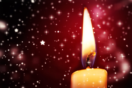 Twinkling stars against candle burning against festive backgroundの写真素材