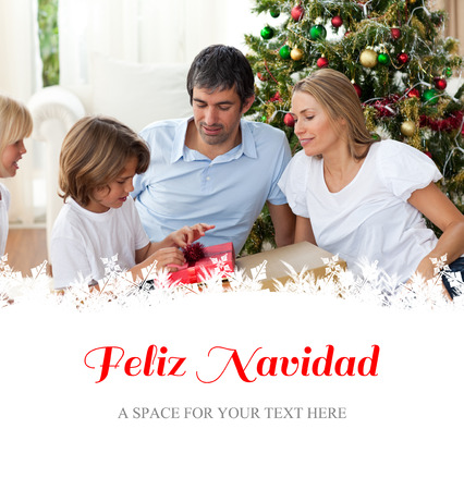 Cheerful family celebrating Christmas against feliz navidadの写真素材