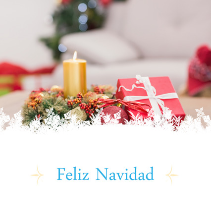 Candle and wreath on table for christmas against Christmas greeting cardの写真素材