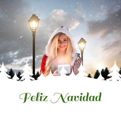 sexy santa girl opening gift against feliz navidadの写真素材