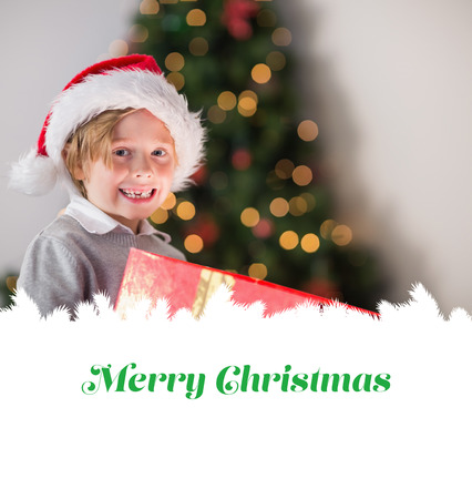 Child opening his christmas present against merry christmasの写真素材