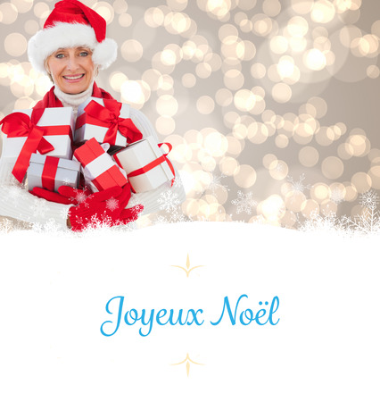 festive woman holding gifts against Christmas greeting cardの写真素材