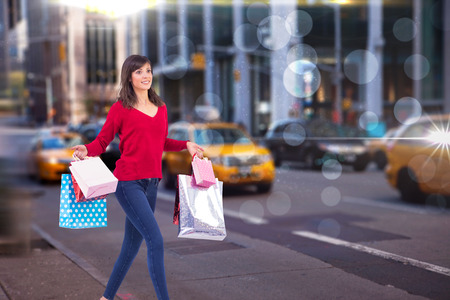 Excited brunette with shopping bags against blurry new york streetの写真素材