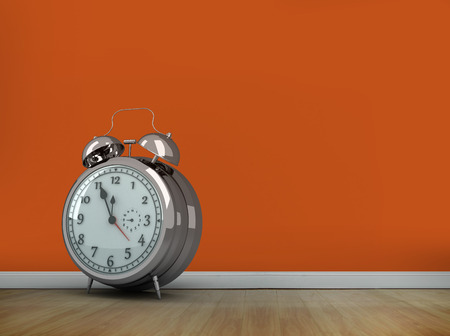 Alarm clock counting down to twelve against room with wooden floorの写真素材