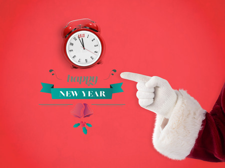 Santa Claus points at something against red backgroundの写真素材