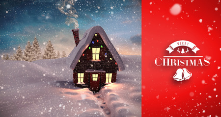 Snow falling against christmas houseの写真素材