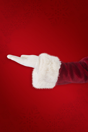 Santa Claus shows open hand against red backgroundの写真素材