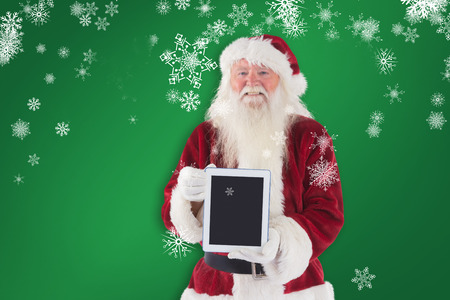 Santa presents a tablet PC against greenの写真素材