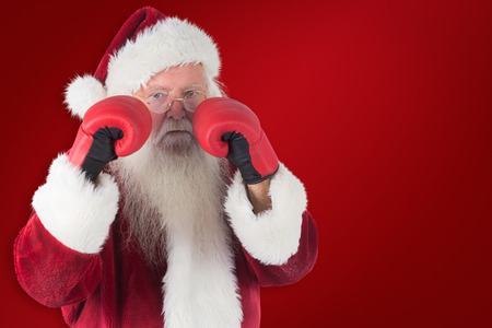 Santa Claus is ready to fight against red backgroundの写真素材