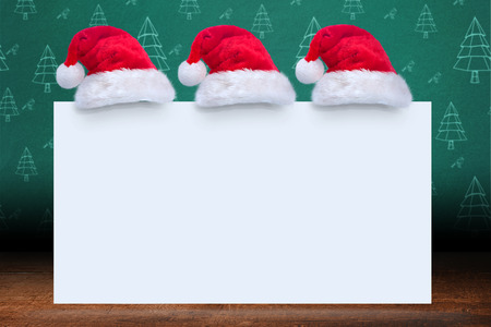 Santa hat on poster against green christmas tree patternの写真素材