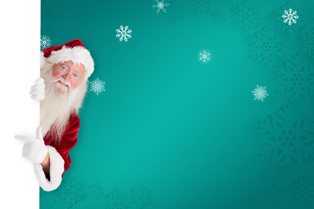 Santa claus showing against green snowflake backgroundの写真素材