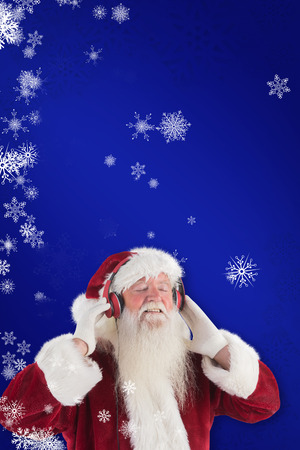 Santa Claus enjoys some music against blueの写真素材
