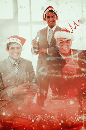 Confident businessmen wearing novelty Christmas hat against glittering christmas tree designの写真素材
