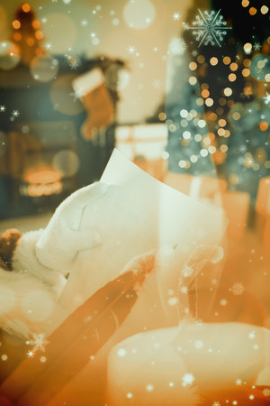 Santa checking his list against candle burning against festive backgroundの写真素材