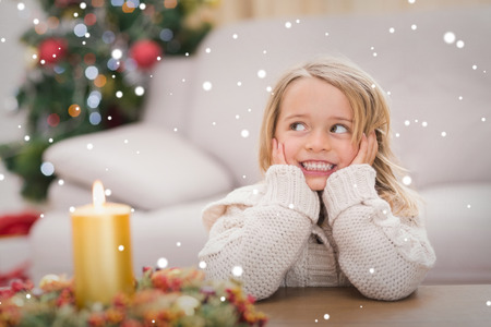 Cute little girl smiling at christmas  against snowの写真素材