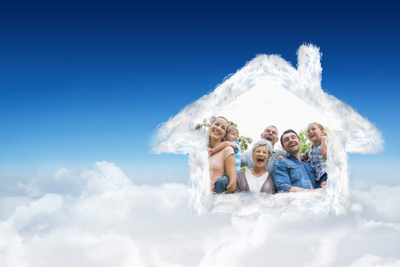 Portrait of cheerful extended family at park against blue sky over cloudsの写真素材