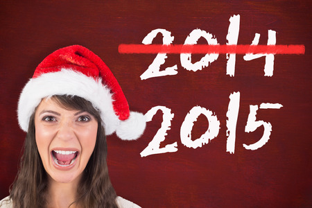 Young woman in santa hat yelling against desk