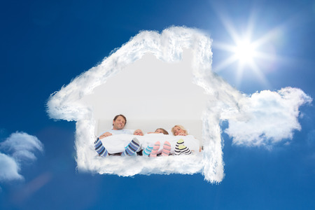 Family wearing stripey socks against bright blue sky with cloudsの写真素材