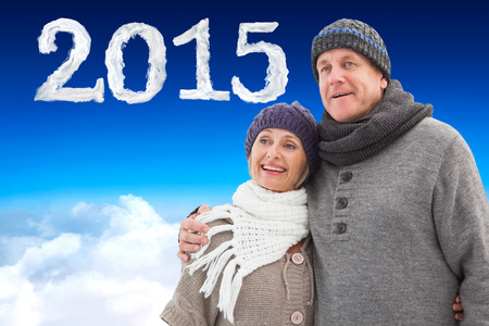 Mature winter couple against blue sky over clouds