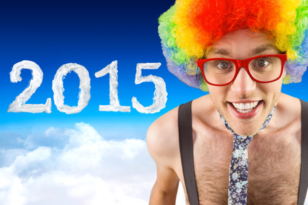 Geeky hipster in afro rainbow wig against blue sky over cloudsの写真素材
